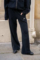 Zwarte wide leg joggingsbroek met reflecterend logo en refecterende strepen op zijkant van naetur